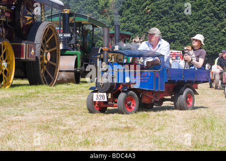 L'homme et de la femme avec des chiens équitation en miniature à vapeur foden wagon Banque D'Images