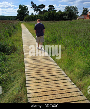 Homme marchant le long d'une promenade en bois portant les noms des donateurs. Banque D'Images