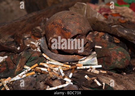 Tana Toraja de Sulawesi Indonésie village Londa cigarettes grotte funéraire comme offrandes avec tête de gauche Banque D'Images