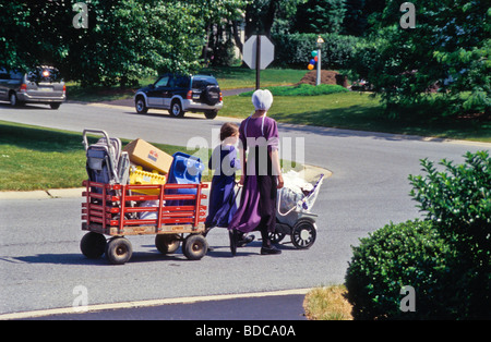 Jeune femme amish & fille recherche d'affaires dans la banlieue de maison familiale, garage vente-débarras. Banque D'Images