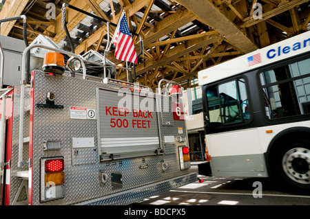 Un autobus de la ville passer un camion de pompiers garé sous la voie ferrée surélevée sur East Lake Street à Chicago, Illinois, USA. Banque D'Images