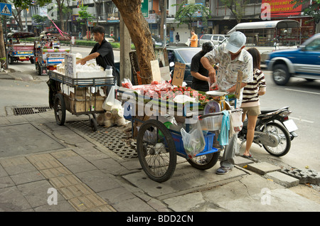Des stands de restauration de rue sont installés sur le pavé de Bangkok Thaïlande Banque D'Images