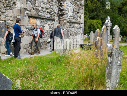 Les gens marcher parmi les pierres tombales et les ruines d'un bâtiment à Glendalough, dans le comté de Wicklow, en République d'Irlande l'été 2009 Banque D'Images