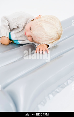Bébé garçon allongé sur un matelas d'air Banque D'Images