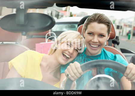 Deux femmes assises dans une voiture après le magasinage Banque D'Images