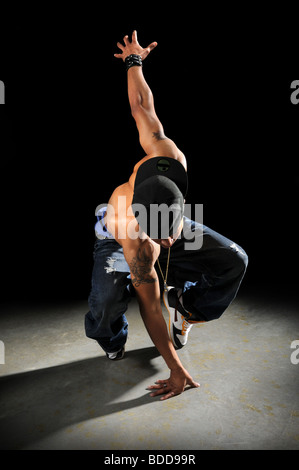 African American hip hop dancer performing sur fond sombre Banque D'Images