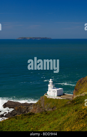 Phare de Hartland point sur la côte nord du Devon avec l'île Lundy à l'horizon, en Angleterre. Banque D'Images