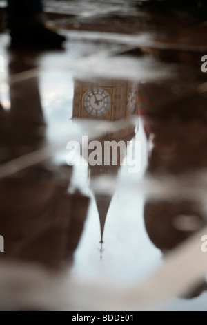 La tour de l'horloge du palais de Westminster (Big Ben) reflète dans une flaque d'eau. Banque D'Images