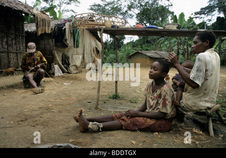 Une mère et sa fille un toilettage pygmée anothers sèche dans un village éloigné dans la forêt tropicale à la frontière du Gabon et du Congo, en Afrique. Banque D'Images