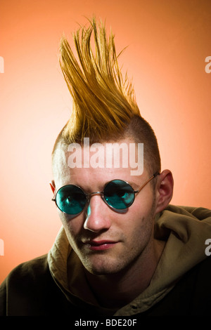 Jeune homme avec une coiffure mohawk, porter des lunettes, de poser. Parution du modèle. Banque D'Images