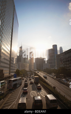 Soir la lumière se reflétant sur la circulation et sur la position à l'égard d'immeubles de grande hauteur à Hong Kong, Chine. Banque D'Images