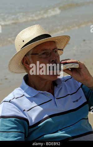 Portrait d'un homme buvant dans une fiole de la hanche Banque D'Images