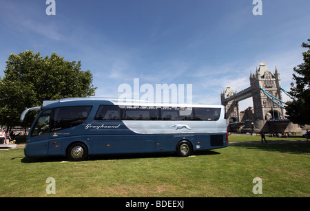 Greyhound bus exploités par Premier groupe en face de Tower Bridge à Londres, Royaume-Uni Banque D'Images