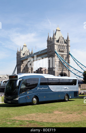 Greyhound bus exploités par Premier groupe en face de Tower Bridge à Londres, Royaume-Uni Banque D'Images