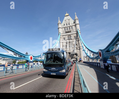 Greyhound bus exploités par Premier groupe en face de Tower Bridge à Londres, Royaume-Uni Banque D'Images