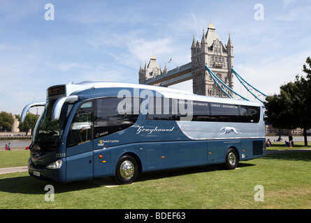 Greyhound bus exploités par Premier groupe en face de Tower Bridge à Londres, Royaume-Uni Banque D'Images