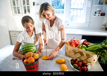 Mère et fille adolescente en cuisine avec les fruits et légumes frais Banque D'Images