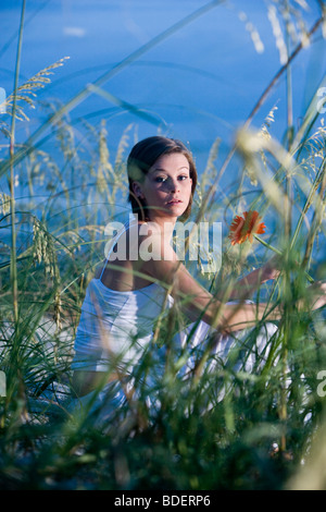 Jolie jeune femme assise sur la plage de dunes de sable et de la mer l'avoine Banque D'Images