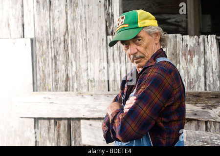 Senior man wearing cap vert, debout près de clôture en bois Banque D'Images