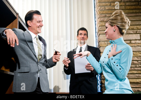 Vintage portrait de jeune secrétaire avec ruche et deux hommes d'in office Banque D'Images