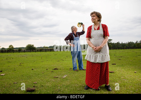 Senior couple standing in green field Banque D'Images