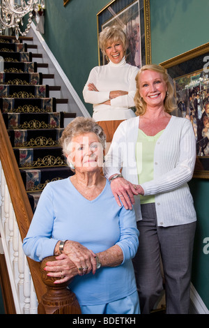 Portrait d'une femme âgée qui posent avec des filles sur l'escalier d'accueil Banque D'Images