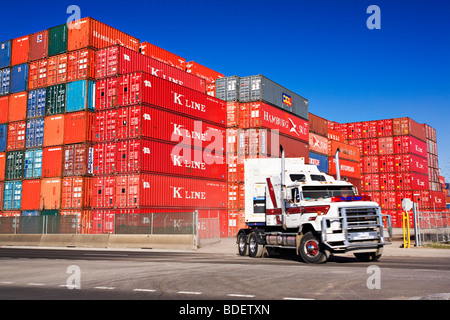 Un camion semi-remorque transporte un conteneur d'un dépôt de conteneurs du port.Le "Port de Melbourne Australie Victoria'. Banque D'Images