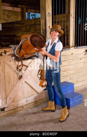 Attractive Woman holding stable en selle Banque D'Images