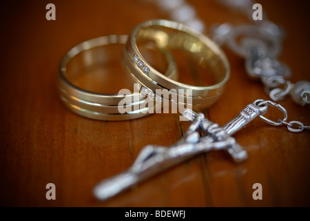 Paire de bagues de mariage avec Christian crucifix sur la chaîne Banque D'Images