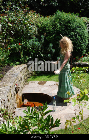 Woman meditating at Glastonbury jardins de Chalice Well Somerset England United Kingdom Banque D'Images