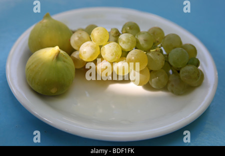 Les figues et les raisins verts sur un tableau bleu Banque D'Images