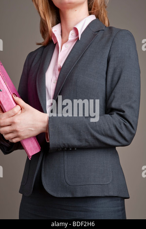 Close-up of woman anonyme, portant costume et réalisation de dossier rose Banque D'Images