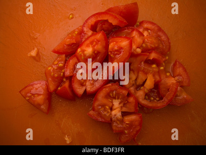 Des tranches de tomate sur une planche à découper dans une cuisine Banque D'Images