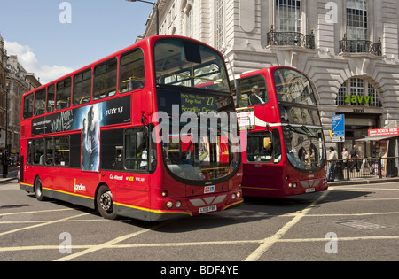 Deux bus à impériale rouge traverser la jonction à Piccadilly Circus, Londres Banque D'Images