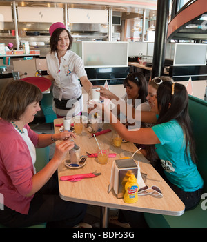 Un teenage waitress une famille, Annettes Diner, Village, Disneyland Paris, France Banque D'Images