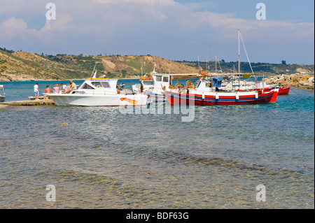 Vue sur plage de galets à l'abri des petits bateaux de pêche avec des bateaux à Katelios sur l'île grecque de Céphalonie, Grèce GR Banque D'Images