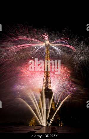 Le jour de la Bastille d'artifice Tour Eiffel Paris France fête de l'indépendance petite silhouette gendarme à base de la tour perspective ajoute Banque D'Images