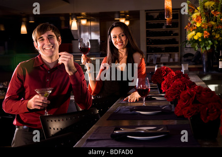 Jeune couple avec boissons au restaurant Banque D'Images