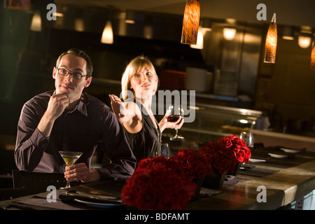 Jeune couple avec boissons au restaurant Banque D'Images