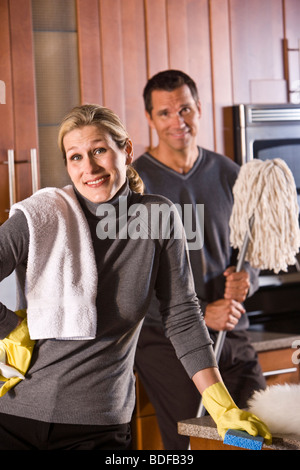 Mid-adult couple nettoyer la cuisine Banque D'Images