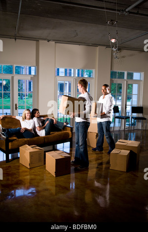 Multi-ethnic friends et des couples avec des cartons dans la salle de séjour Banque D'Images