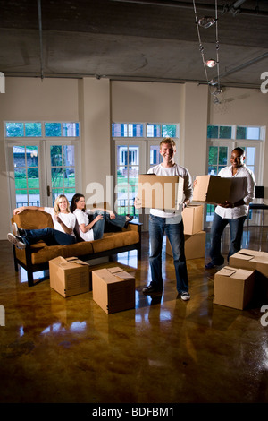 Multi-ethnic friends et des couples avec des cartons dans la salle de séjour Banque D'Images