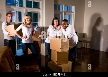 Multi-ethnic friends et des couples avec des cartons dans la salle de séjour Banque D'Images