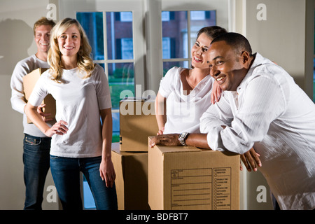 Multi-ethnic friends et des couples avec des boîtes de déménagement Banque D'Images