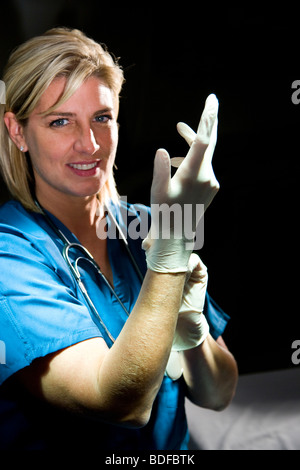 Femme médecin mise sur des gants chirurgicaux Banque D'Images