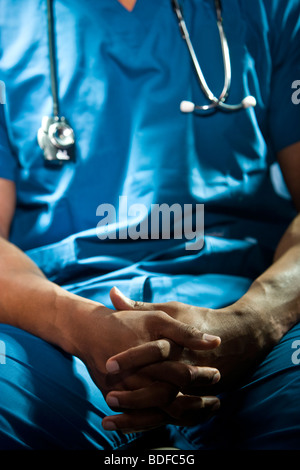 Au milieu du médecin afro-américain en bleu frotte avec les mains jointes Banque D'Images