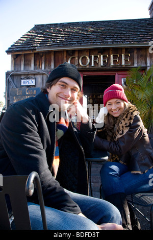Portrait of young couple in habillement chaud assis au café-restaurant en plein air Banque D'Images