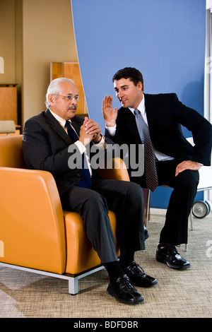 Portrait de deux Business People talking in office lounge area Banque D'Images