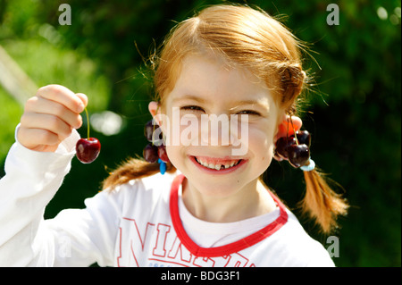 Girl joue avec cerises Banque D'Images