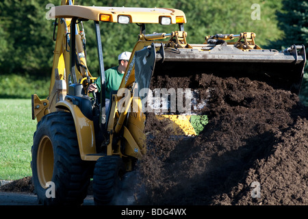 Déménagement mulch avec un tracteur John Deere et véhicule utilitaire. Banque D'Images